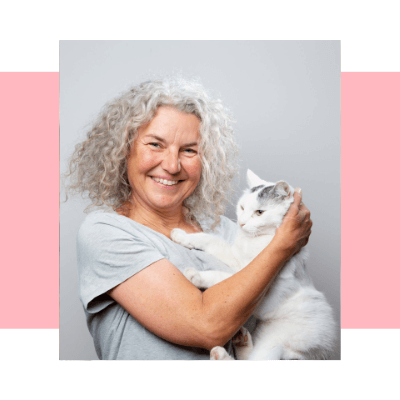 An impage of a happy woman hugging a cat